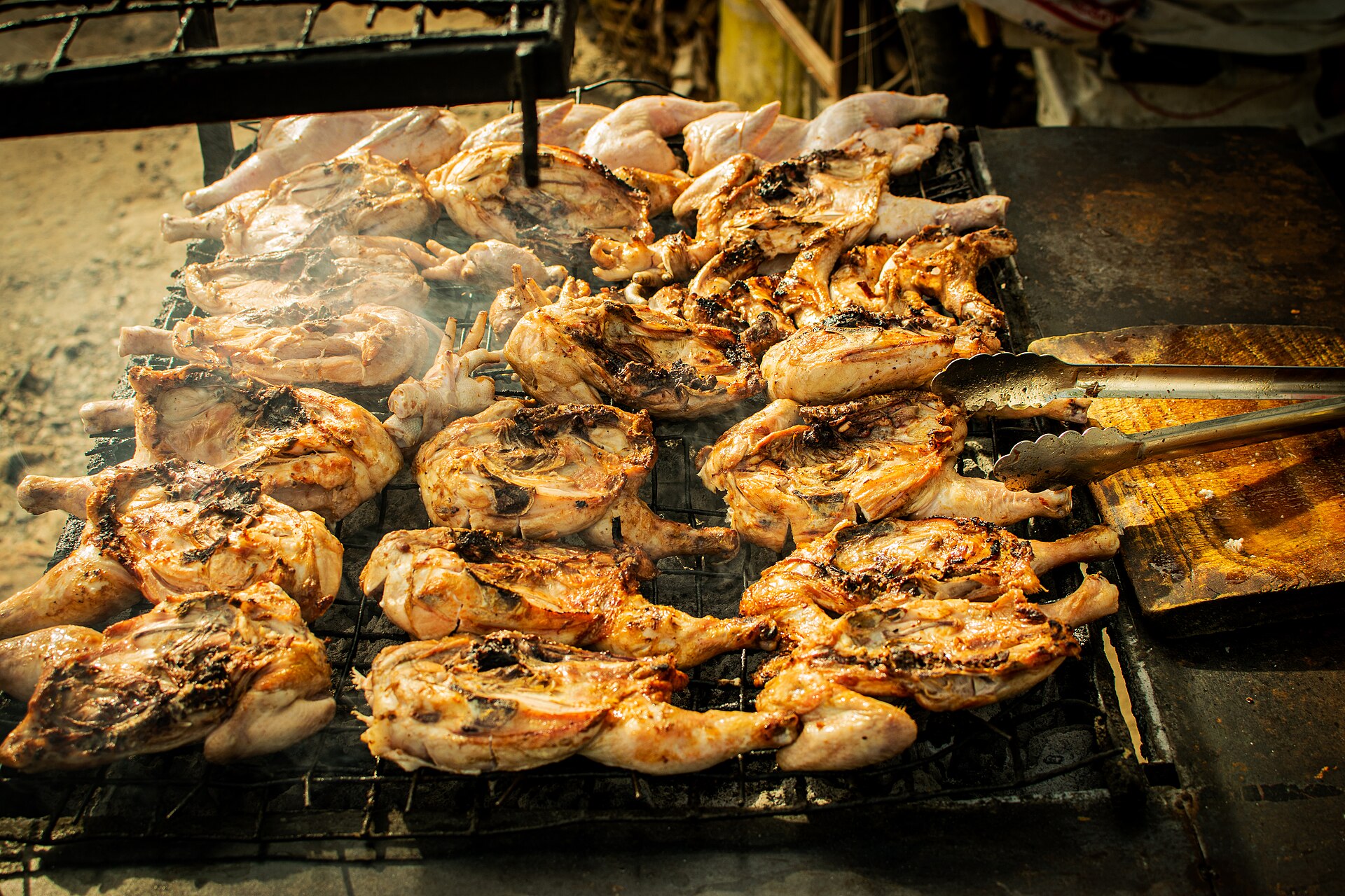 Chicken grilling over charcoal
